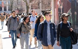 Students walk past the Sacco and Vanzetti mural