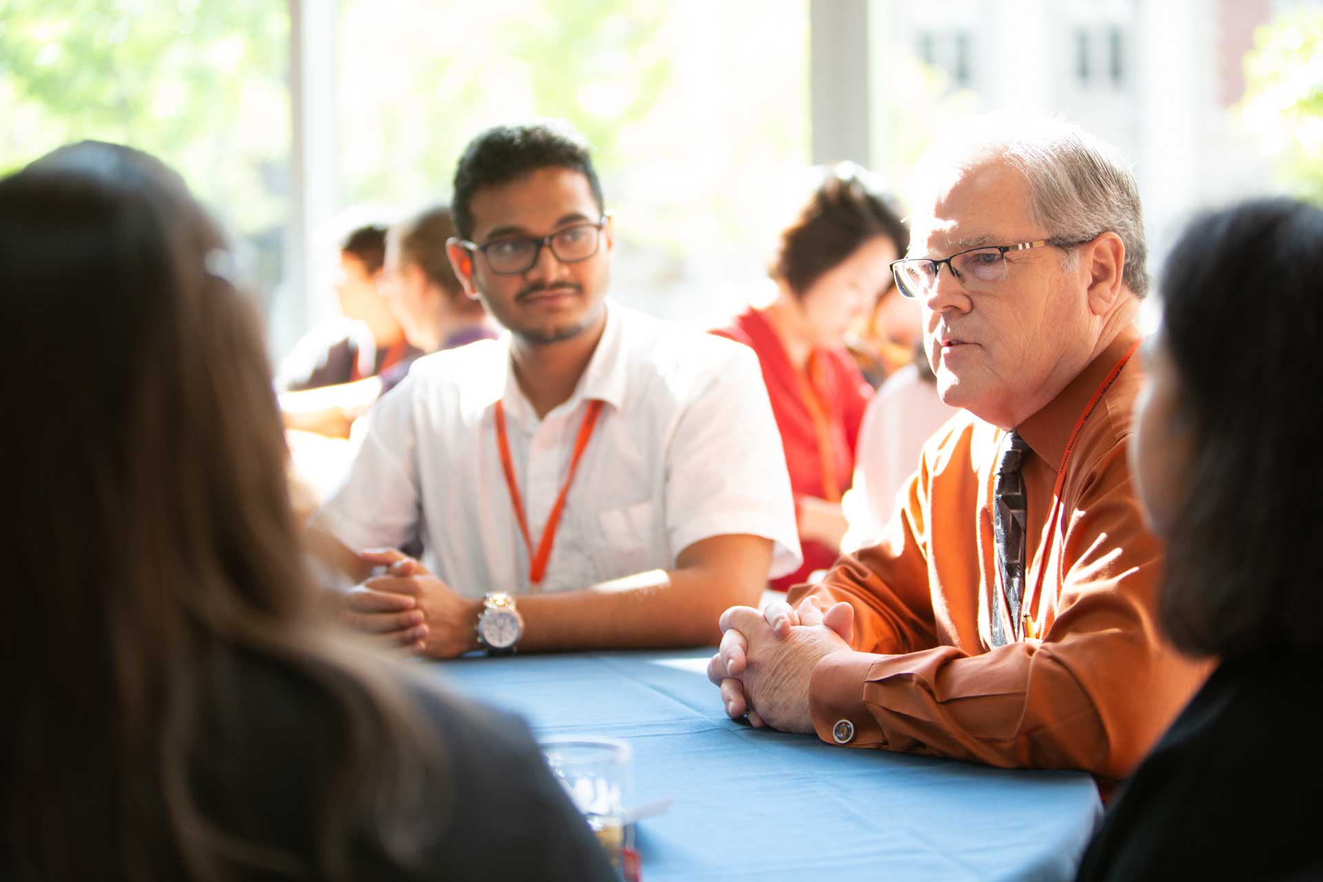 Students and faculty at table chatting