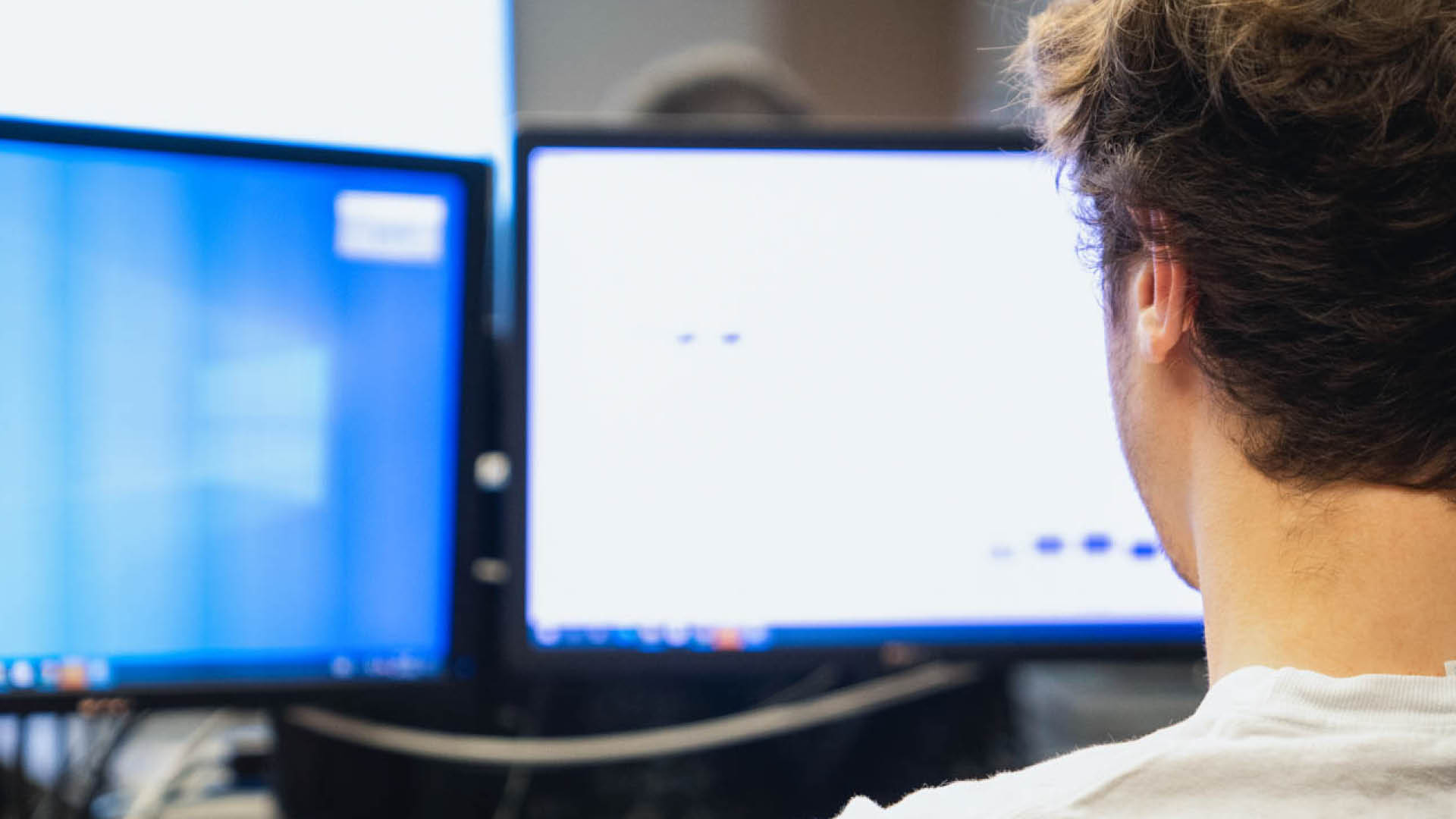 young man working on two screens